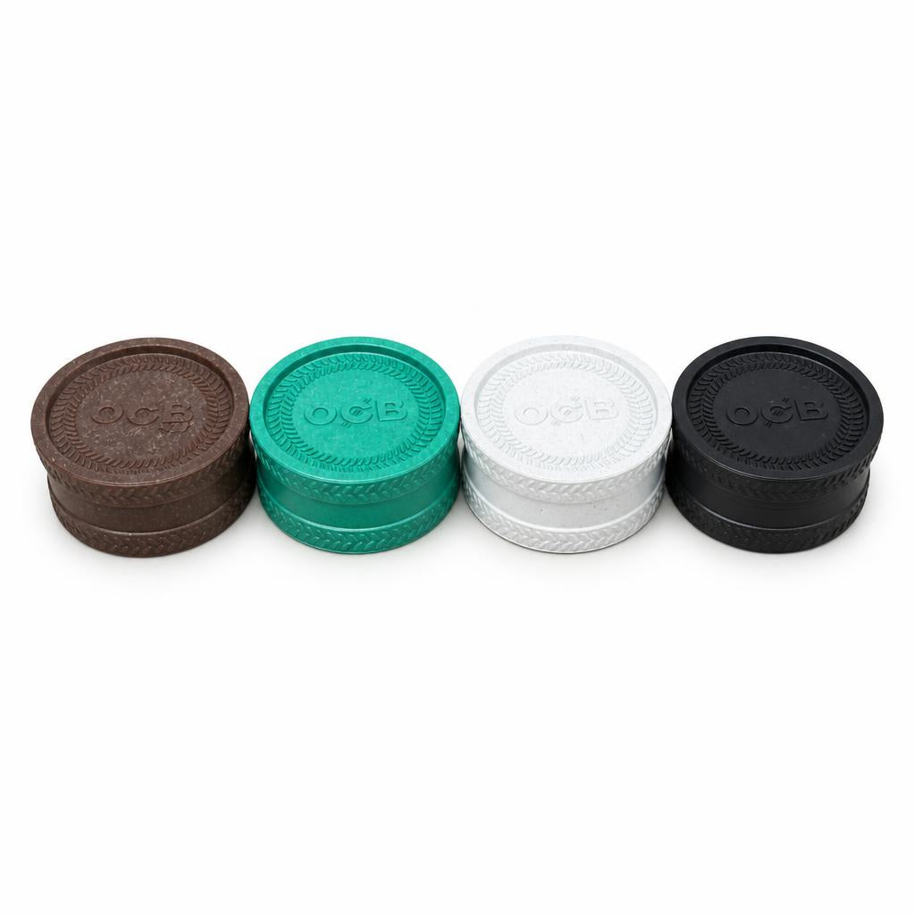 OCB plastic herb grinders in brown, green, white, and black.